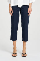 Person wearing navy blue pants and a white shirt on a white background