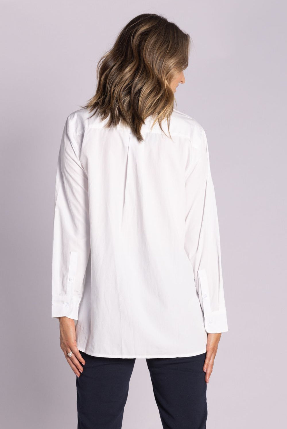 White Chloe Shirt – breathable cotton, viscose & tencel blend with side splits, rounded hemline, and button front. Shop now at Silvermaple Boutique.