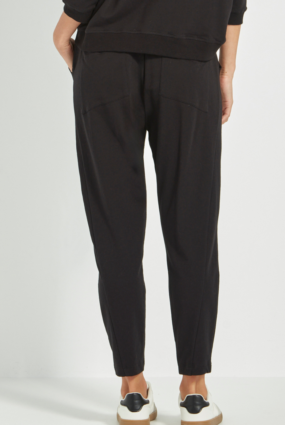 Woman wearing Verge Civic Pant, Black with a Black Top with white sneakers. Shop Silvermaple Boutique now.