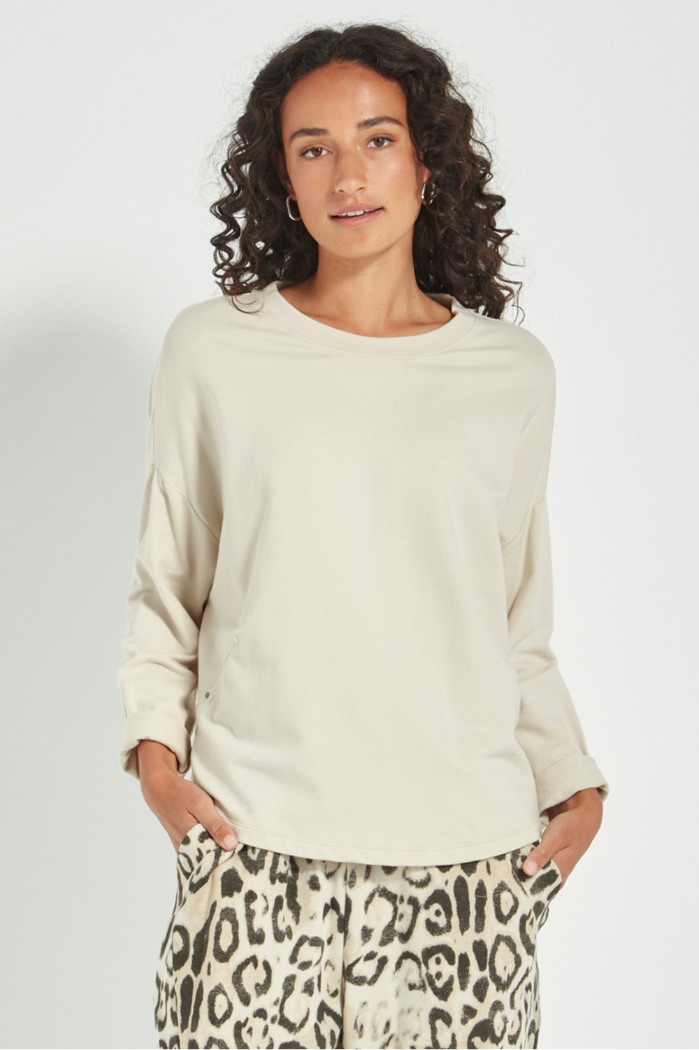 Woman wearing the new Verge Downtown sweater in cashew with leopard print pants, available online at Silvermaple Boutique.