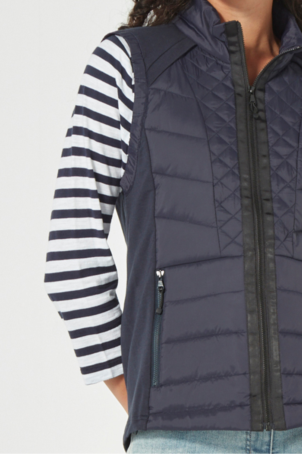 Woman wearing a striped shirt, Verge Idaho Vest Ink with light blue jeans on a white background. Available online at Silvermaple Boutique.