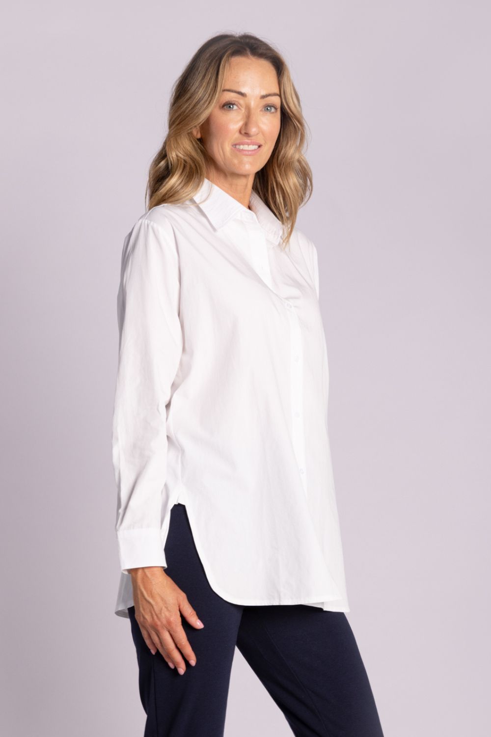 White Chloe Shirt – breathable cotton, viscose & tencel blend with side splits, rounded hemline, and button front. Shop now at Silvermaple Boutique.