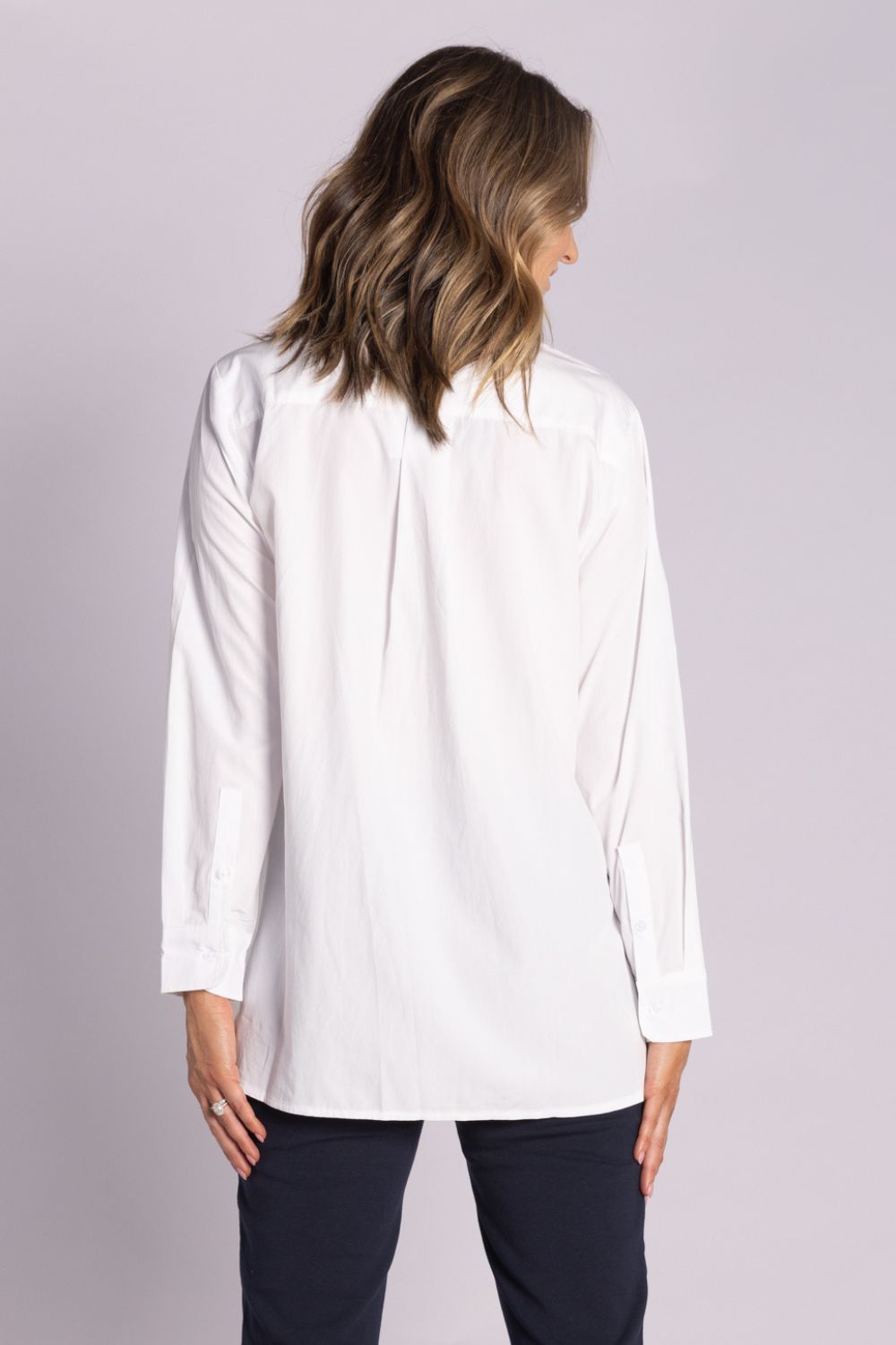 White Chloe Shirt – breathable cotton, viscose & tencel blend with side splits, rounded hemline, and button front. Shop now at Silvermaple Boutique.