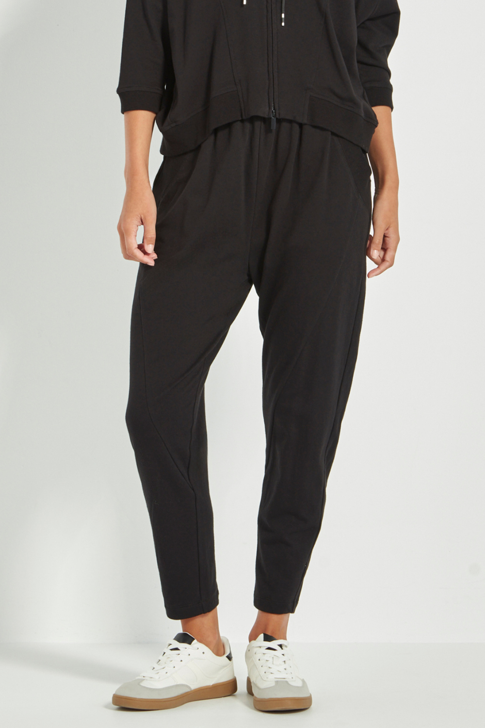 Woman wearing Verge Civic Pant, Black with a Black Top with white sneakers. Shop Silvermaple Boutique now.