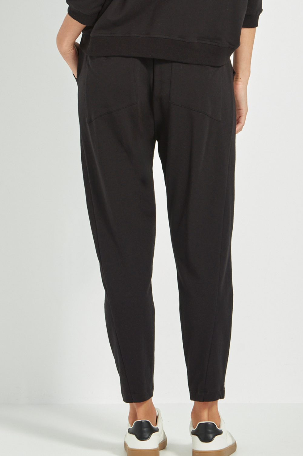Woman wearing Verge Civic Pant, Black with a Black Top with white sneakers. Shop Silvermaple Boutique now.