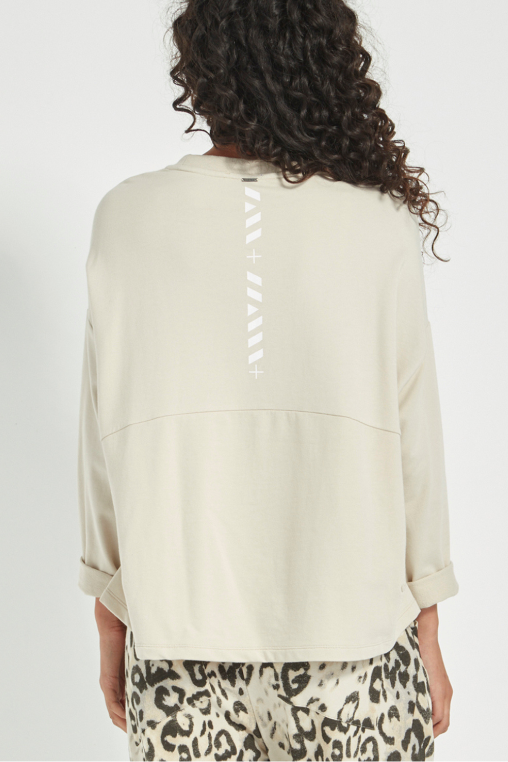 Woman wearing the new Verge Downtown sweater in cashew with leopard print pants, available online at Silvermaple Boutique. 